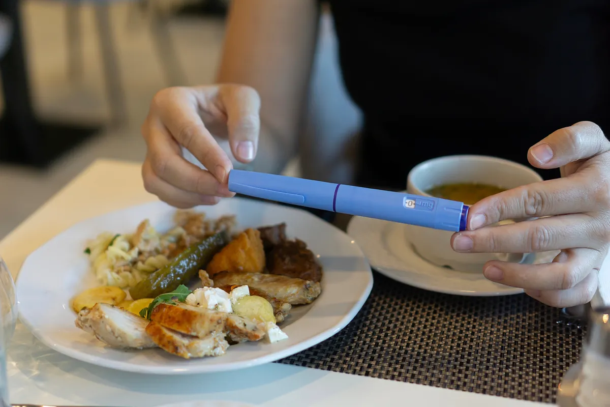 A woman with an Ozempic dose beside food and soup, as credited on the source page.