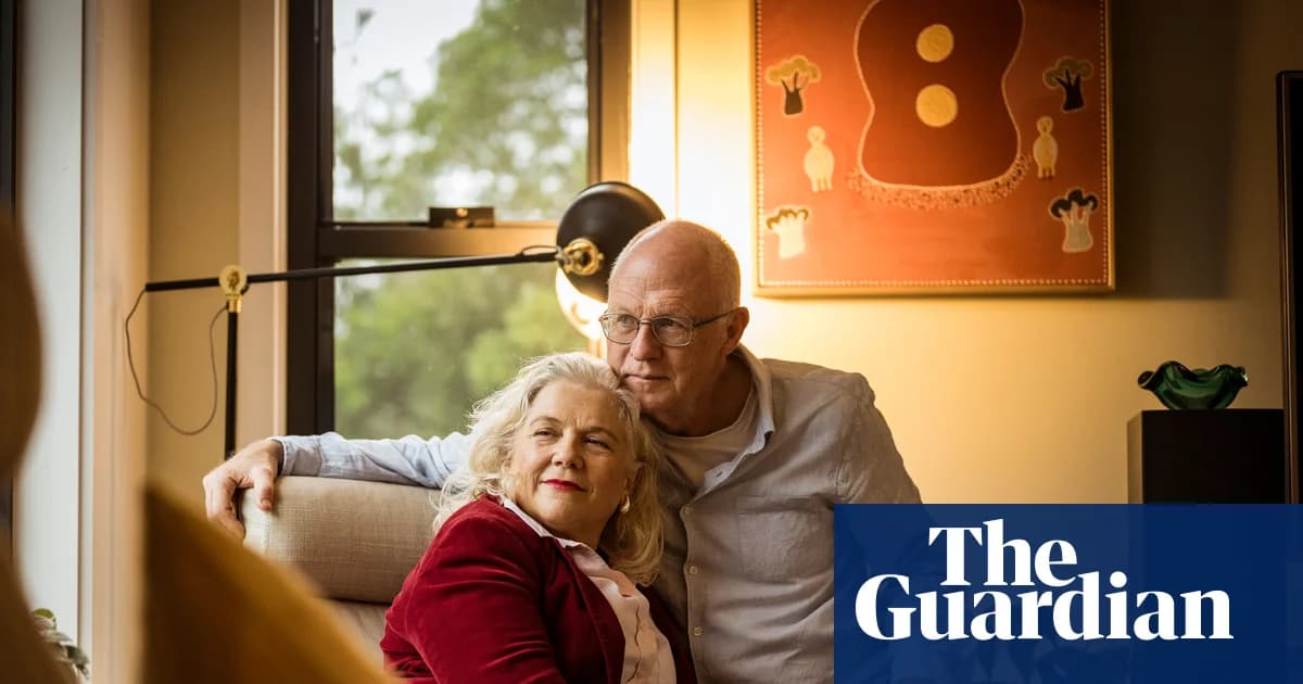 Joanna Wood and Bruce Hart sit together in a living room.